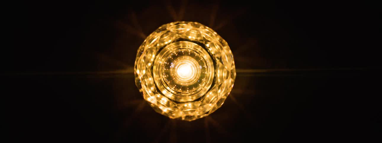 A disco light chandelier mounted on the ceiling spinning and flickering colorful lights across the room