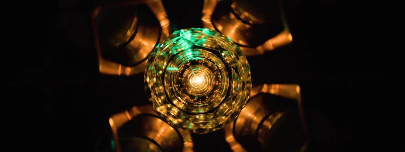 A chandelier spinning on the ceiling displaying different colors of light