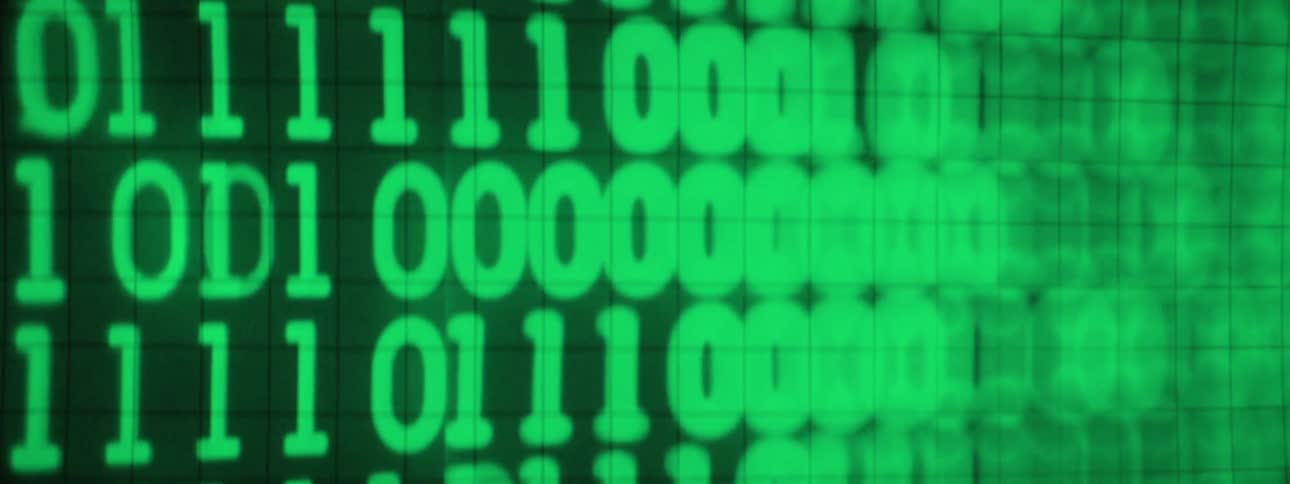 Green rows of numbers one and zero flashing on monitor