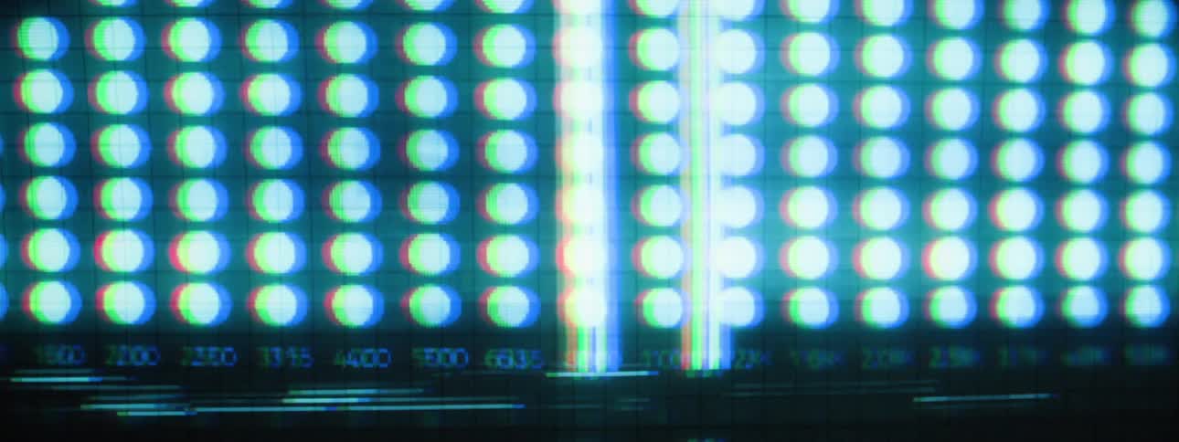 A digital screen initially displaying a sequence of blue dots aligned with numerical values beneath them which then transitions into a display of distorted glitchlike horizontal lines