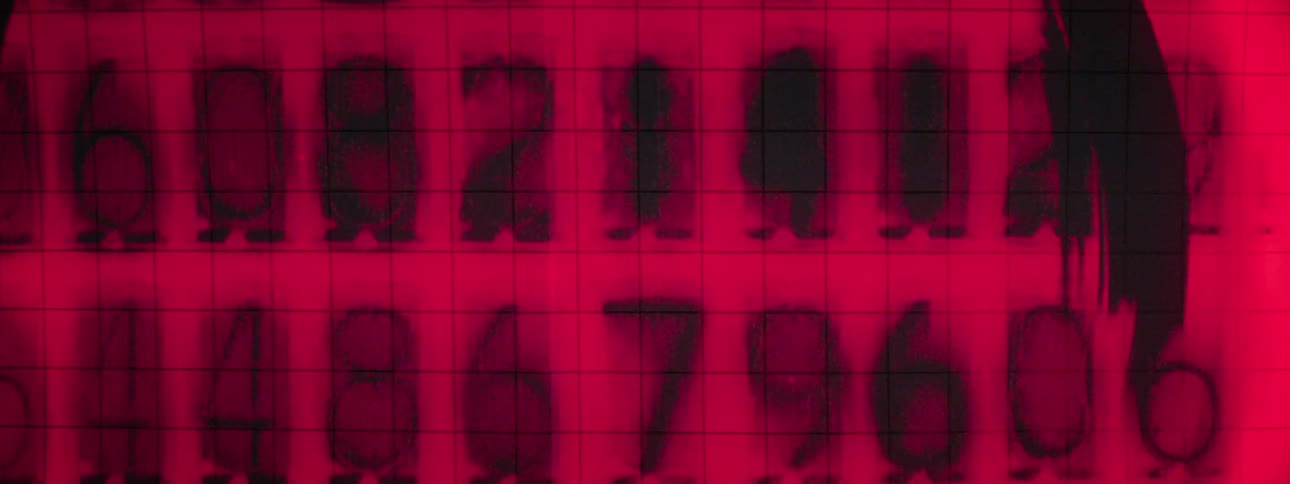 Rows of numbers change rapidly against a red background