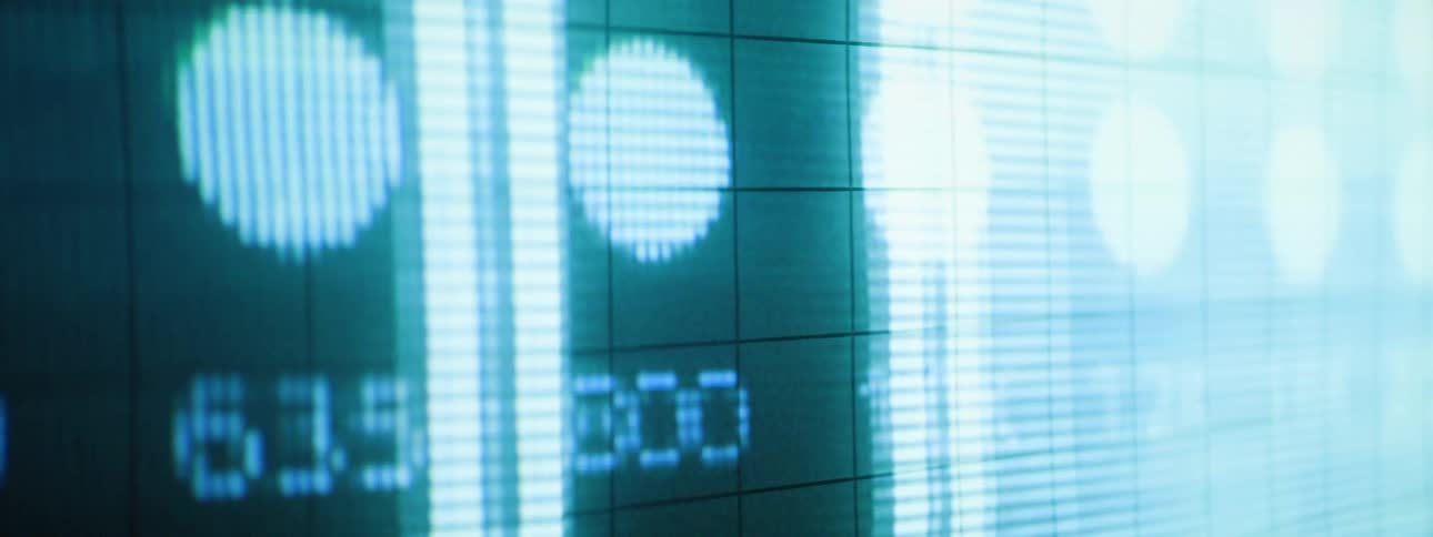 Bright blue numbers and circular patterns are displayed on a dark gridded electronic screen followed by abstract lines