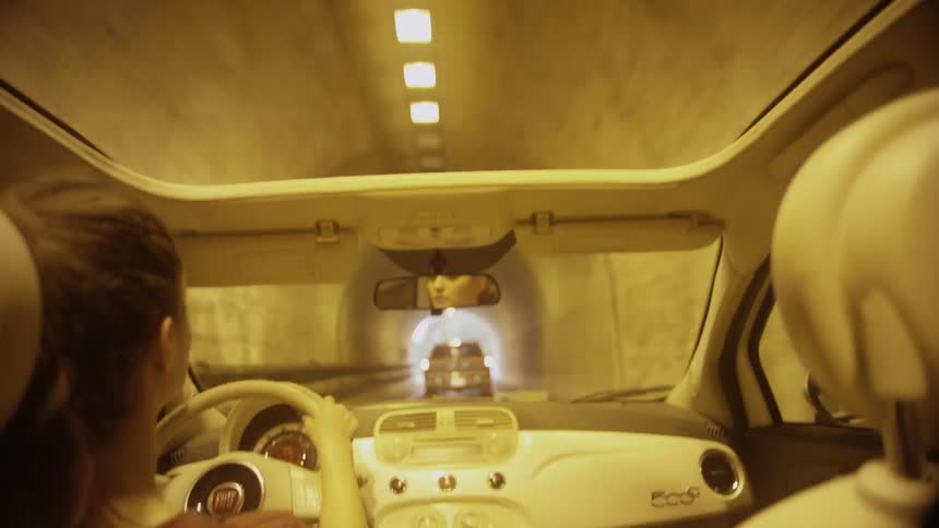 A view of a tunnel while a woman is driving in it