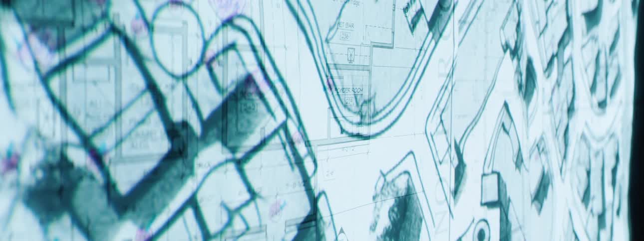Multiple layers of architectural blueprints with detailed floor plans and dimensions are superimposed creating a complex and technical visual