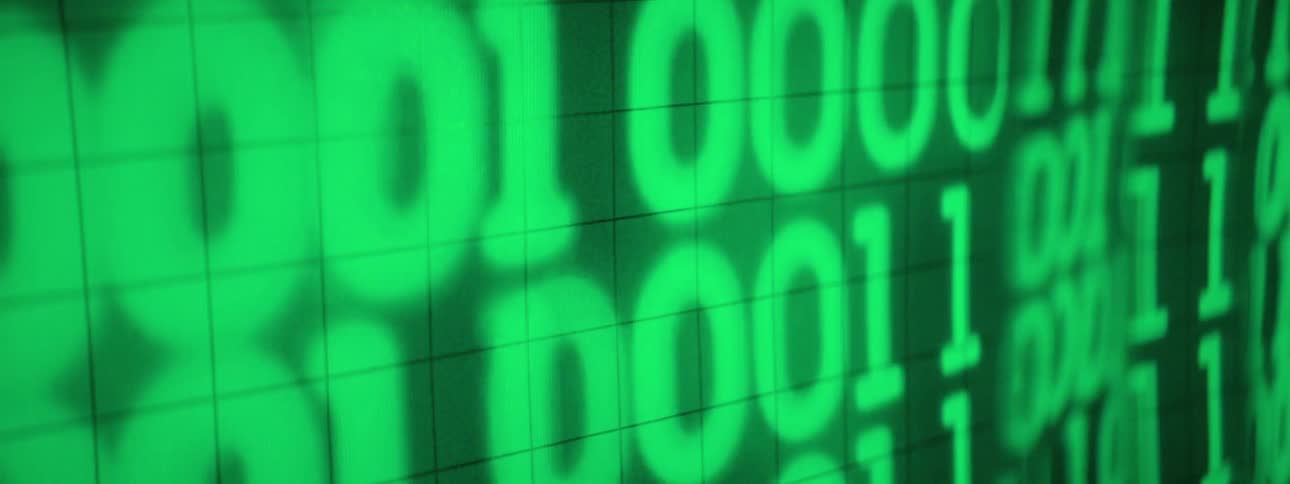A digital display shows glowing green binary code composed of ones and zeros arranged in rows on a dark gridded background