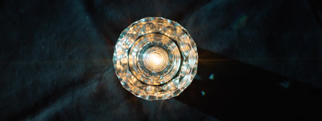 A chandelier light fixture spinning on the ceiling while emitting a warm light