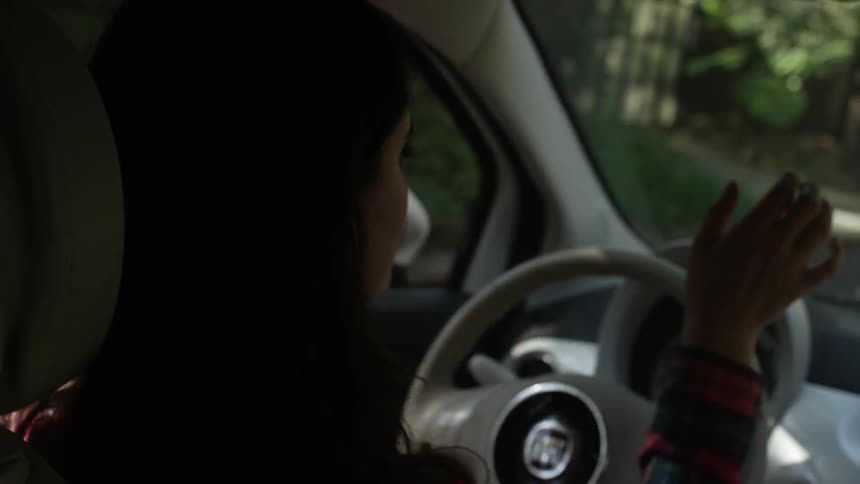 A woman is driving a car