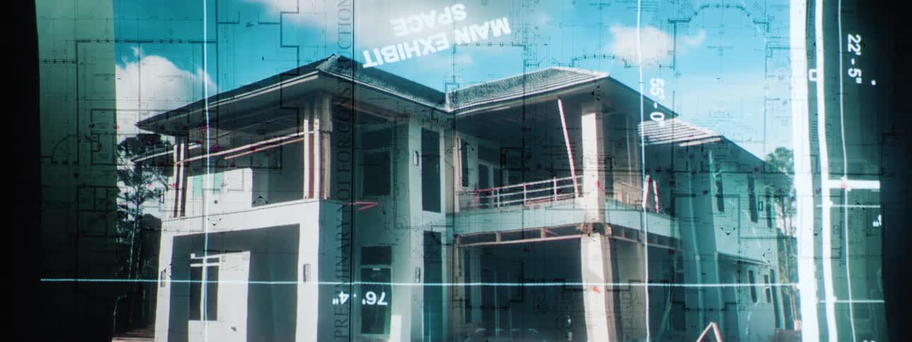 A partially constructed twostory houses superimposed over architectural blueprints and a sky with clouds