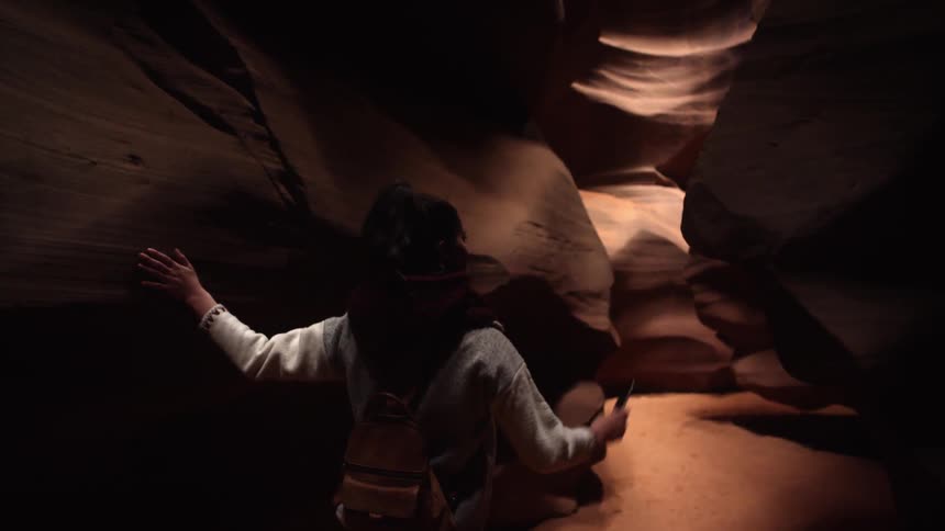 A woman is making her way through a chasm and touching its sides