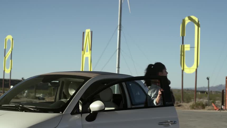 A woman gets out of her car in the parking lot