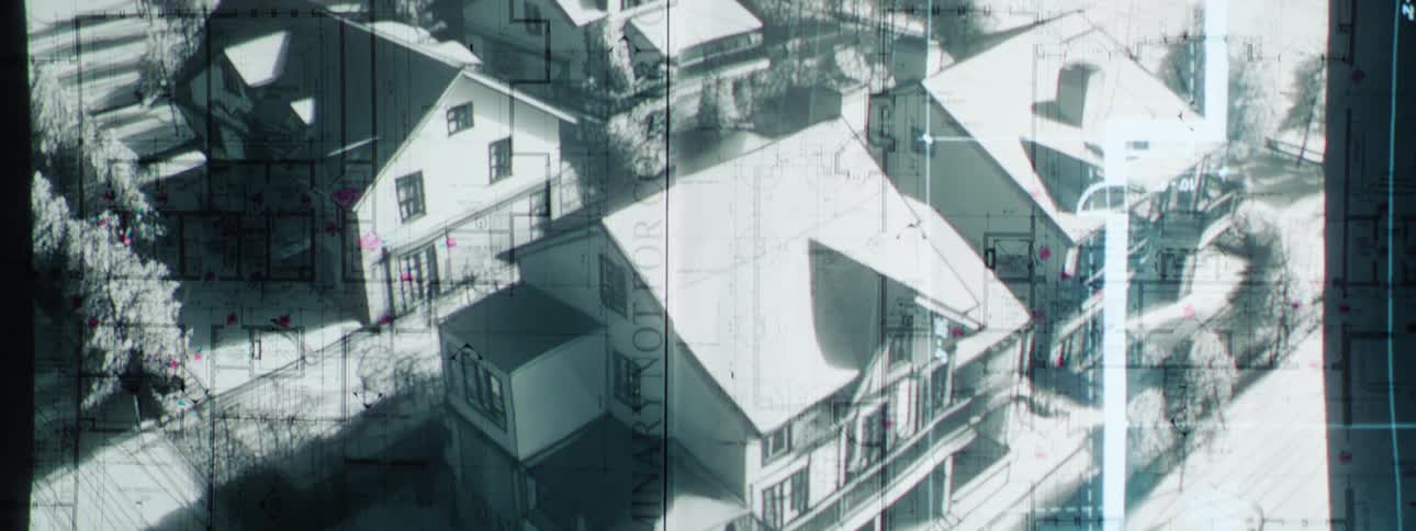 A blueprint is projected superimposed over a drawing of homes