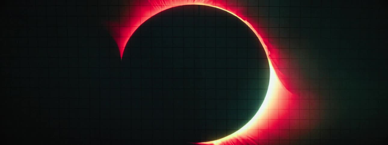 A dark circular object is intensely backlit with a fiery red and white corona against a dark subtly textured background