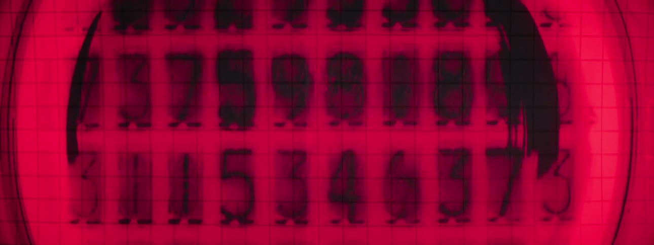 Numbers flash rapidly on a display in a circle illuminated by a red light