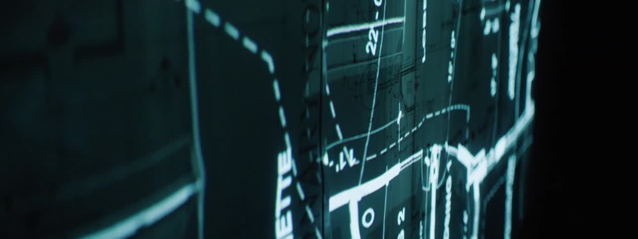 A screen shows a digital image of a blueprint of an area of buildings