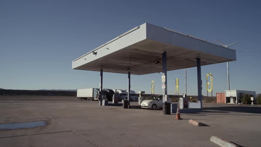 A person gets gas at a gas station