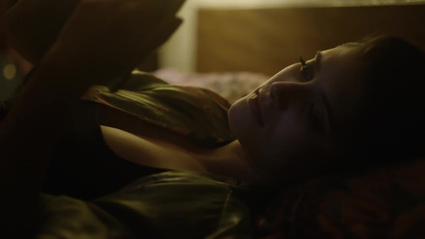 A woman laying in a room looking at something in her hand