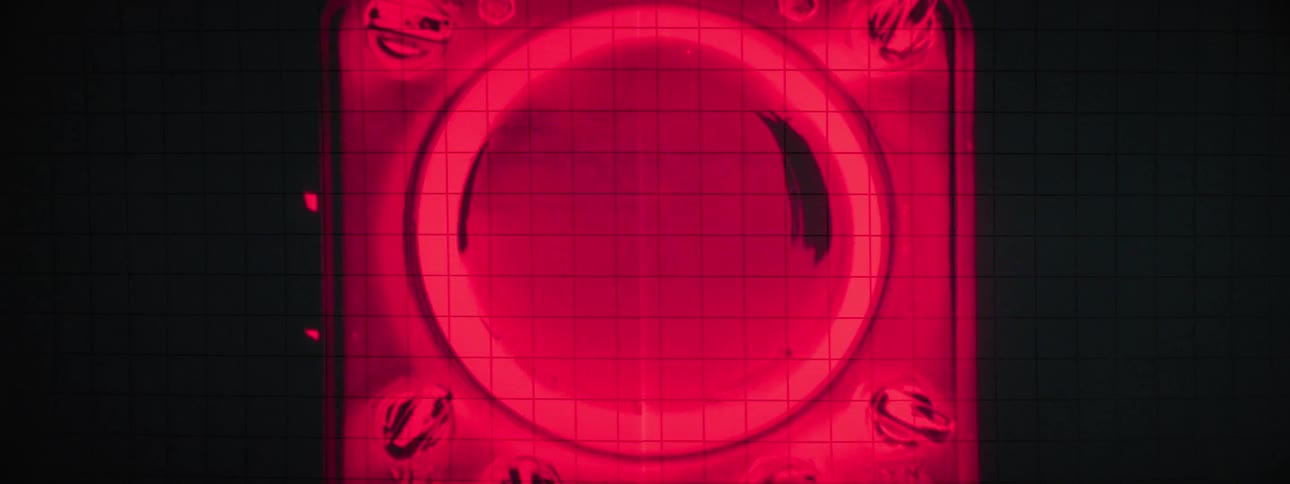 A device with a circular screen blinking and displaying a distorted red image