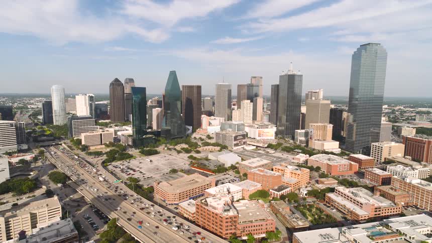 Heavy traffic is entering a downtown area with the skyscrapers concentrated in the center of downtown