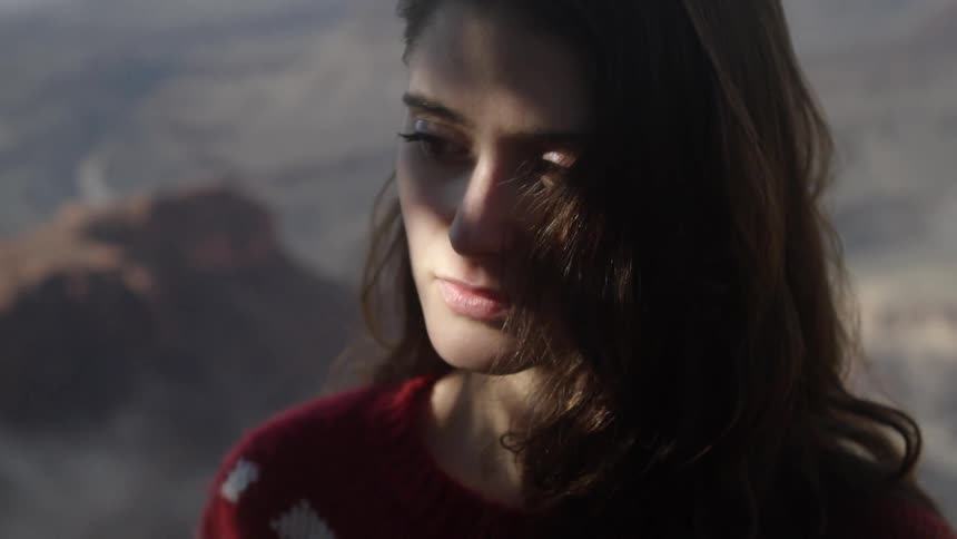 A woman looks down with shade over her face