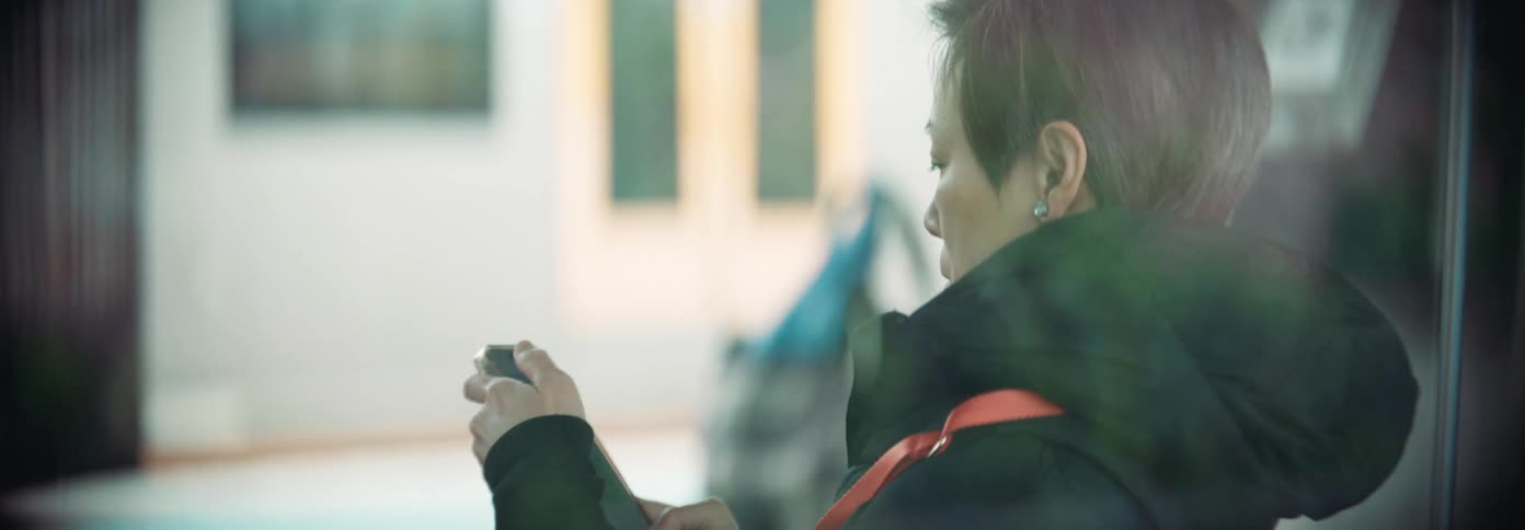 A woman standing still using her phone