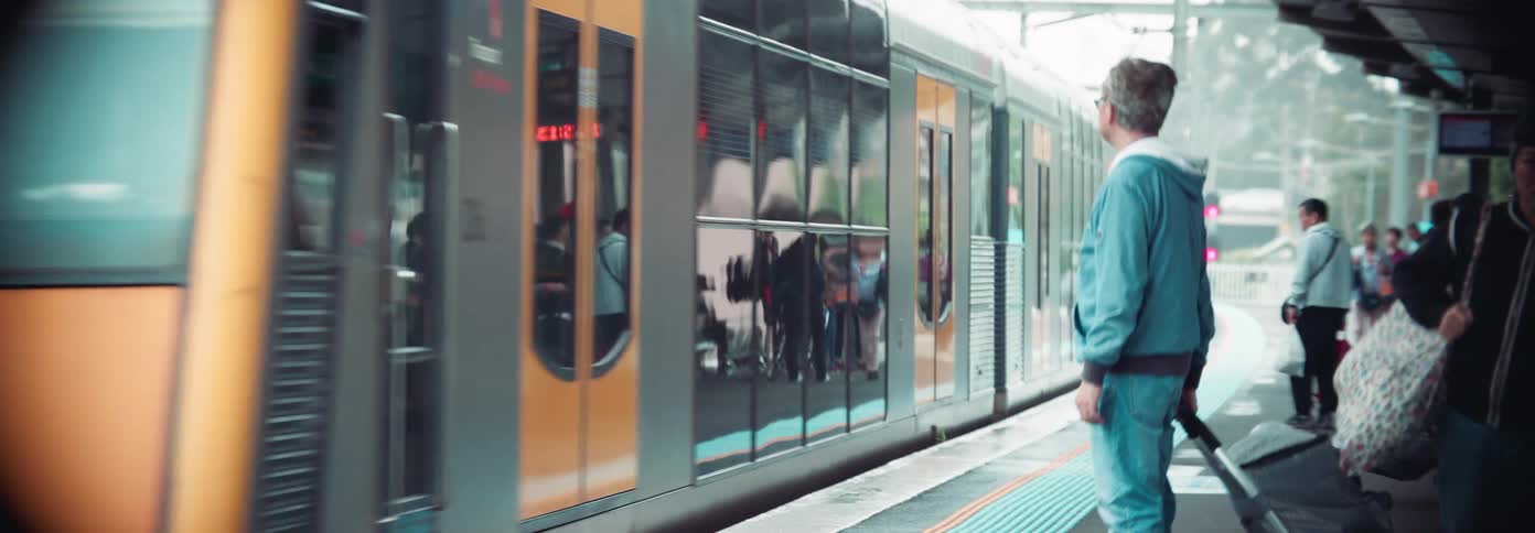 Train approaches a busy and populated station during daytime