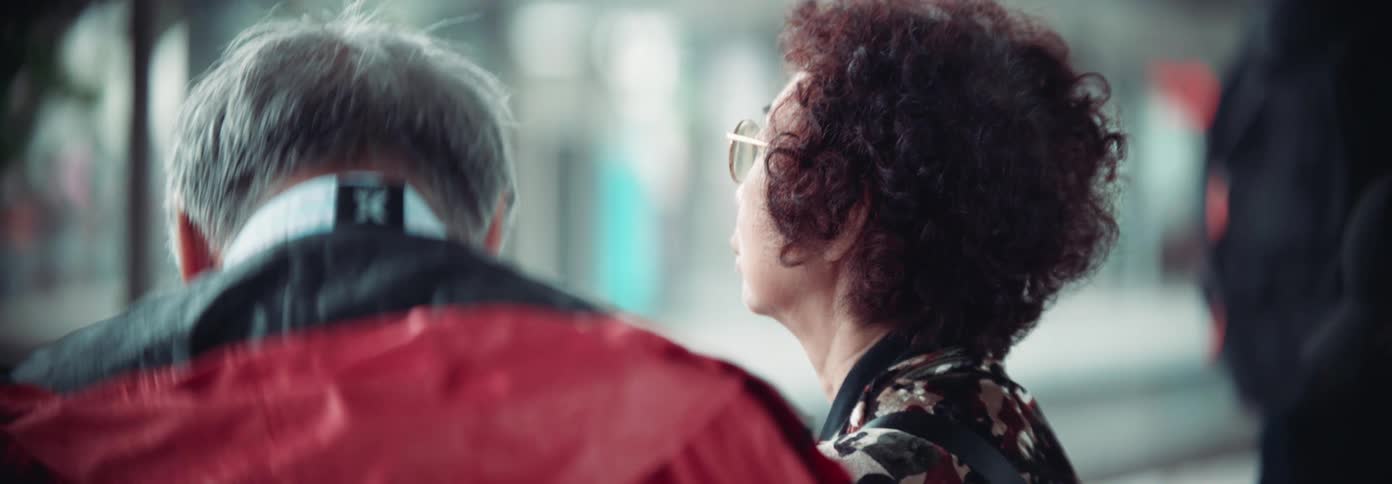 People sit at a train station and wait for the train during the day