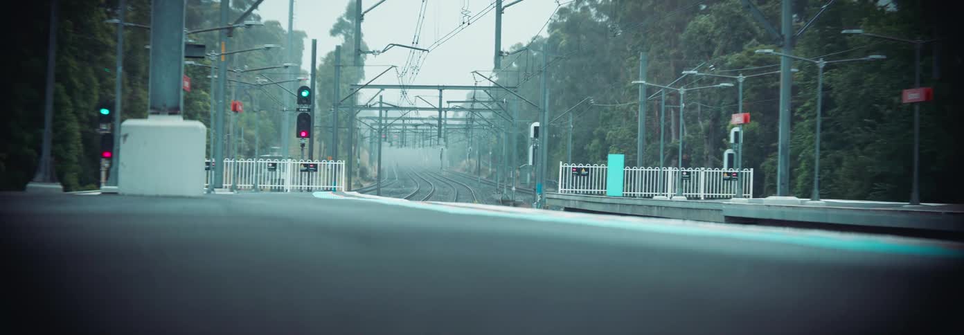 Empty railway station with tracks and signals under overcast skies