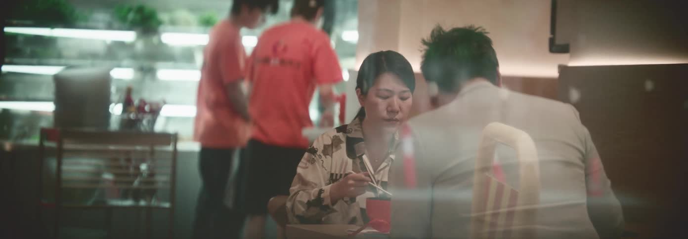 An asian couple share a meal at a table in a restaurant