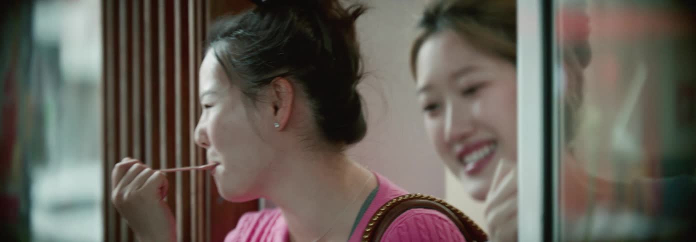 Two girls talk while eating ice cream