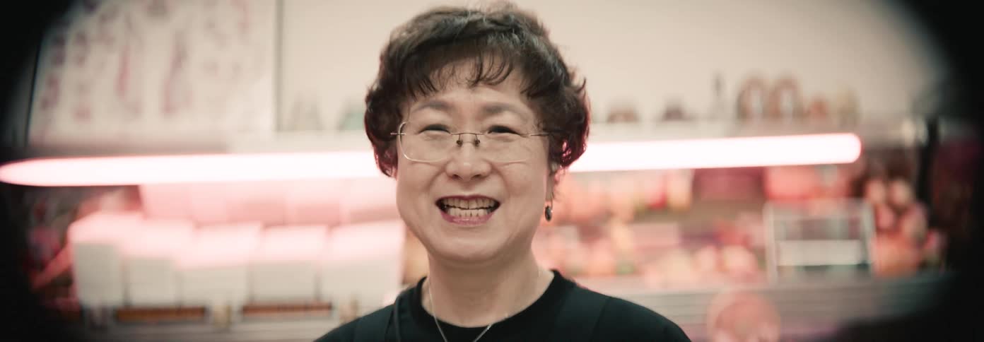 A woman stands and smiles