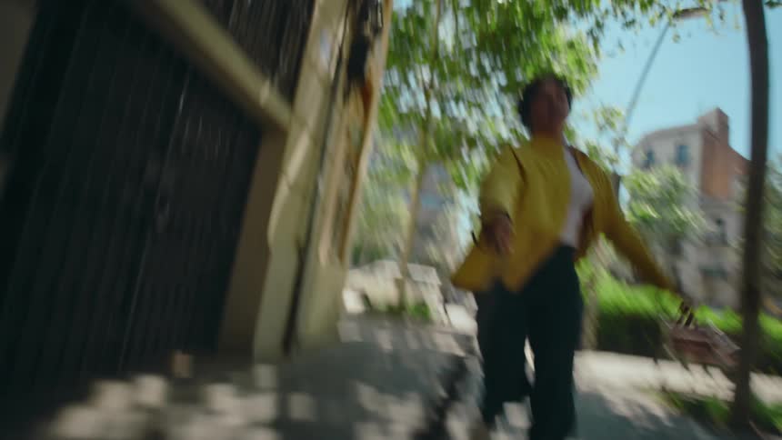 Dog's POV looking back at his owner being pulled along by his leash as he excitedly runs down the city sidewalks.