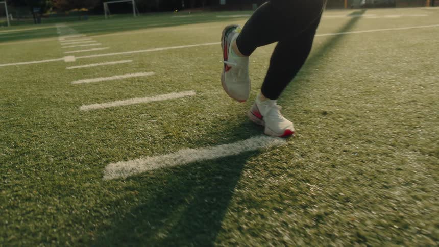 A woman is running on the football field