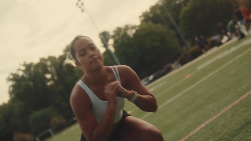 A woman is working out on the football field