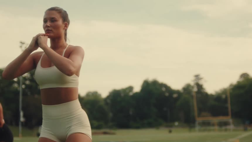 3 women exercise on a field during the day