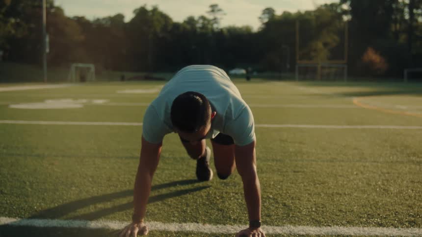 Man doing anaerobic exercise on an outdoor sports grass field