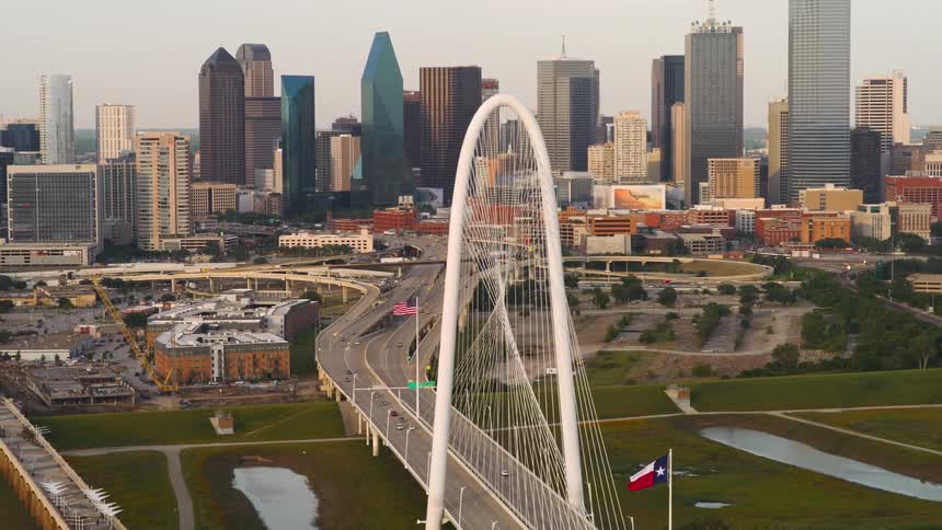 The margaret hunt hill bridge in dallas texas with its iconic arched structure and the dallas skyline in the background