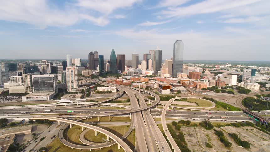 Aerial view of a busy city with intersecting highways and moving traffic