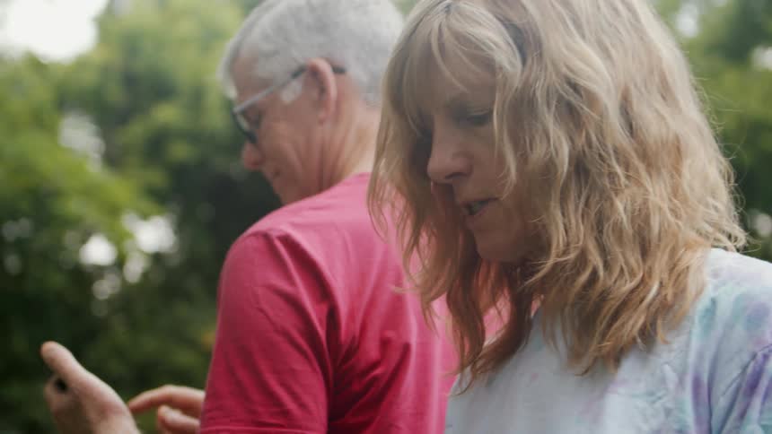 A man and woman are talking and using their cell phones
