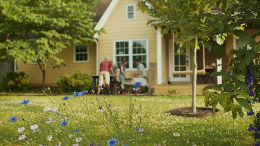 People with a dog in a grassy yard