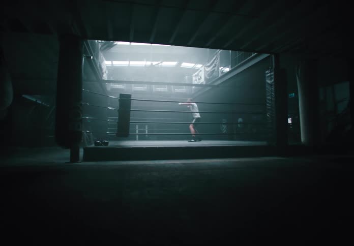 A man trains alone in a boxing ring at midday shadow boxing in preparation for a fight