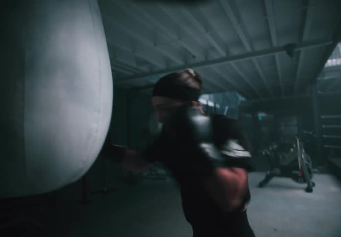 A woman is punching the heavy bag