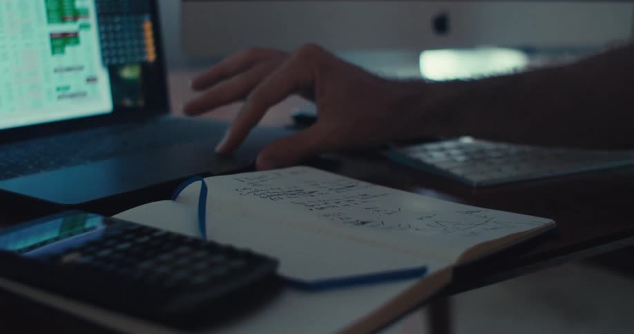 A man is using his laptop at the desk