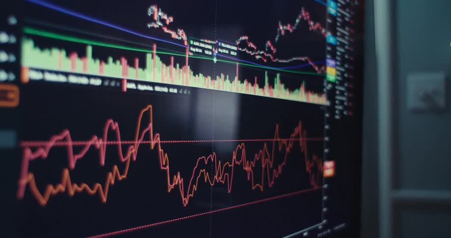 A computer screen displays fluctuating stock market charts and trading data