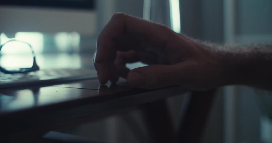 A closeup shot of a male hand tapping fingers rhythmically on a table surface