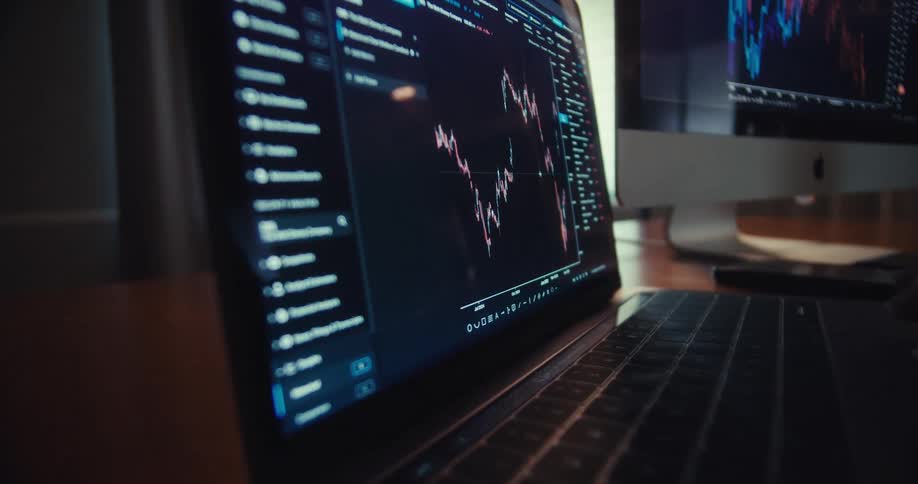The laptop shows moving lines on a graph