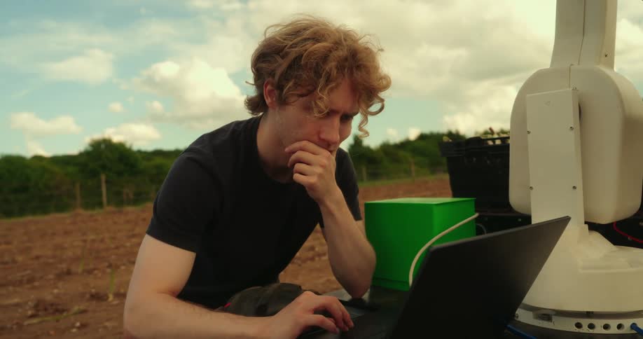 Young agricultural scientist researching on a farm with equipment and laptop