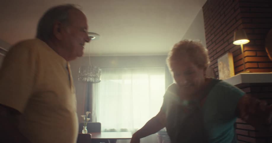 Happy older couple dancing and having fun in thier living room