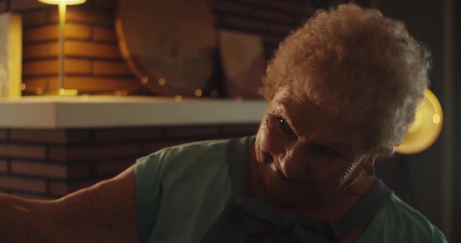An elderly couple joyfully dances salsa together indoors holding hands and smiling