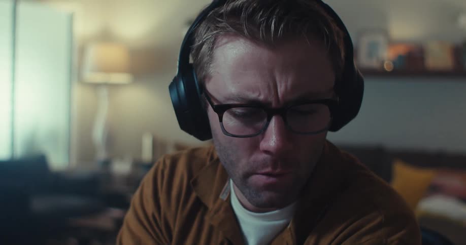 A man is talking and removes his glasses