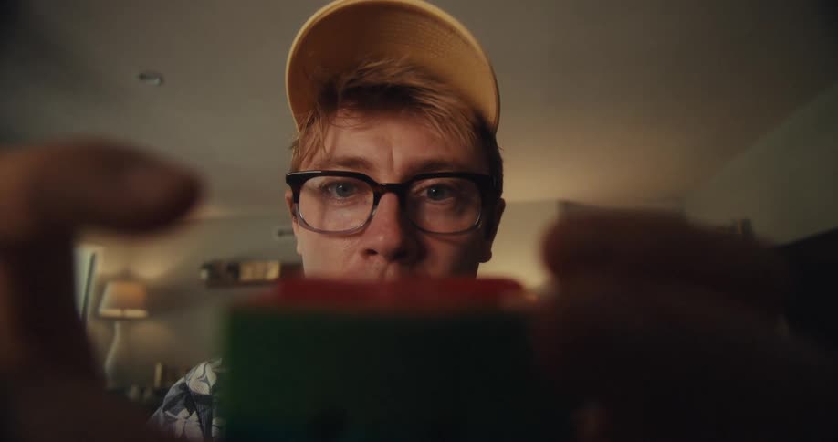 Man celebrates after solving a rubiks cube in a living room